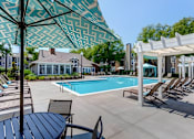 Thumbnail 2 of 13 - A pool area with a white canopy and a table and chairs.