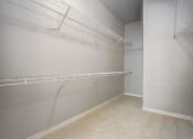 Thumbnail 11 of 36 - the walk in closet of a studio apartment with shelves and racks