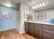 Thumbnail 9 of 36 - an open bathroom with a large mirror and wooden cabinets