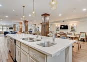 Thumbnail 15 of 36 - a large kitchen with an island and a dining room with tables and chairs