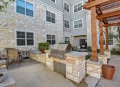 Thumbnail 27 of 36 - a backyard with a grill and a patio with a table and chairs