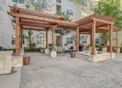 Thumbnail 29 of 36 - a patio with a pergola and a table and chairs