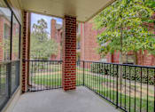 Thumbnail 11 of 34 - a balcony with a black railing and a brick building in the background