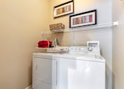 Thumbnail 30 of 52 - A white washing machine with a red towel on top of it.