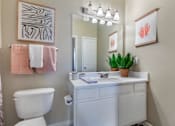 Thumbnail 29 of 52 - A bathroom with a white toilet, sink, and a pink towel hanging on the wall.