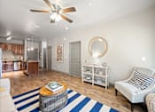 Thumbnail 7 of 36 - a living room with a ceiling fan and a blue and white rug