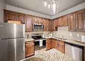 Thumbnail 3 of 36 - a kitchen with wooden cabinets and granite countertops