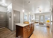 Thumbnail 4 of 36 - a kitchen with an island and a living room in the background