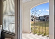 Thumbnail 15 of 36 - a patio with a view of a grassy field and houses in the background