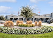 Thumbnail 32 of 36 - a circular flower garden in front of a building