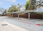 Thumbnail 31 of 36 - a covered parking lot with trees in the background