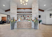 Thumbnail 19 of 36 - a lobby with a reception desk and large vases with flowers on the floor