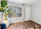 Thumbnail 5 of 47 - a living room with a large window and a potted plant