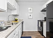 Thumbnail 2 of 47 - a kitchen with white cabinets and black appliances