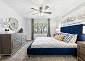 Thumbnail 6 of 47 - a bedroom with a bed and a ceiling fan