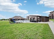 Thumbnail 31 of 33 - a building with a pool in front of a grassy field