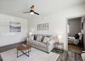 Thumbnail 3 of 33 - a living room with a couch and a ceiling fan
