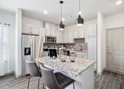 Thumbnail 4 of 33 - a kitchen with white cabinets and a marble counter top