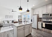 Thumbnail 5 of 33 - an open kitchen and living room with a marble counter top