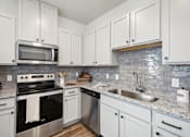 Thumbnail 6 of 33 - a kitchen with white cabinets and stainless steel appliances