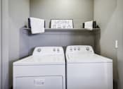 Thumbnail 11 of 33 - a washer and dryer in a laundry room with a shelf on the wall