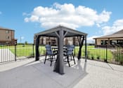 Thumbnail 28 of 33 - a patio with a table and chairs under a gazebo
