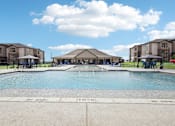 Thumbnail 13 of 33 - a large swimming pool with apartments in the background