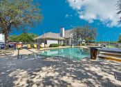Thumbnail 33 of 40 - a resort style pool with a building in the background