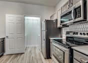 Thumbnail 6 of 35 - A kitchen with a black stove top oven and a black refrigerator.