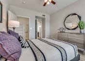 Thumbnail 7 of 35 - A bedroom with a bed, dresser, and mirror.