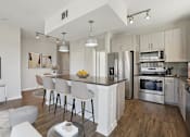 Thumbnail 4 of 55 - A modern kitchen with large granite island counter.