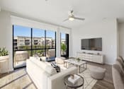 Thumbnail 6 of 55 - A spacious, well-lit living room with floor-to-ceiling windows with a view of Plano, Texas.