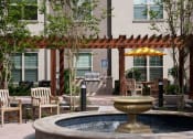 Thumbnail 15 of 28 - a fountain in a courtyard with tables and chairs