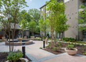 Thumbnail 19 of 28 - a courtyard with a fountain and trees in front of an apartment building