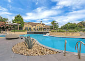 Thumbnail 22 of 35 - Curved pool edge with stone landscaping, agave plantings, and handrails at entry.