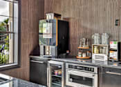 Thumbnail 28 of 35 - Refreshment station with countertop appliances, storage cabinetry, and tea display.