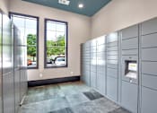 Thumbnail 35 of 35 - Secure package locker room with electronic kiosks, tall windows, and tiled flooring.