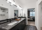 Thumbnail 10 of 35 - Bathroom with double-sink vanity, granite countertop, and walk-in closet access.