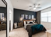 Thumbnail 9 of 35 - Bedroom view with nightstands, modern lighting, and soft carpet under a ceiling fan.