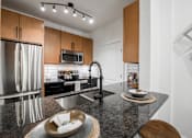 Thumbnail 5 of 35 - Kitchen island with granite countertop, undermount sink, and stainless steel appliances.