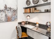 Thumbnail 17 of 35 - Built-in desk nook with granite work surface, floating shelves, and task lighting.