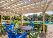 Thumbnail 17 of 25 - A patio with a table and chairs overlooking a pool.