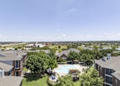 Thumbnail 24 of 25 - A large apartment complex with a pool and a view of the water.