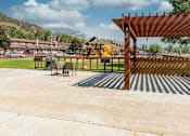 Thumbnail 4 of 18 - a patio with a pergola and a playground in the background