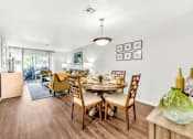 Thumbnail 12 of 42 - a dining room with a table and chairs and a living room in the background