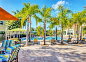 Thumbnail 24 of 42 - a swimming pool with chaise lounge chairs and palm trees