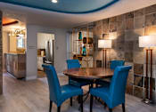 Thumbnail 26 of 45 - a dining area with a table and chairs and a kitchen in the background