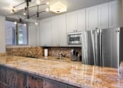Thumbnail 19 of 45 - a kitchen with white cabinets and a granite counter top