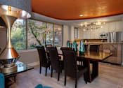 Thumbnail 20 of 45 - a dining room with an orange ceiling and a long wooden table with black chairs