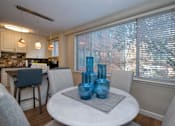 Thumbnail 4 of 45 - a dining room with a table and chairs and a kitchen in the background